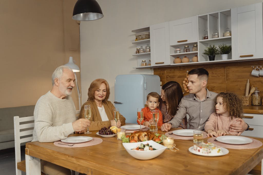 A multi-generational family enjoying a dinner together in a warm, cozy kitchen setting.