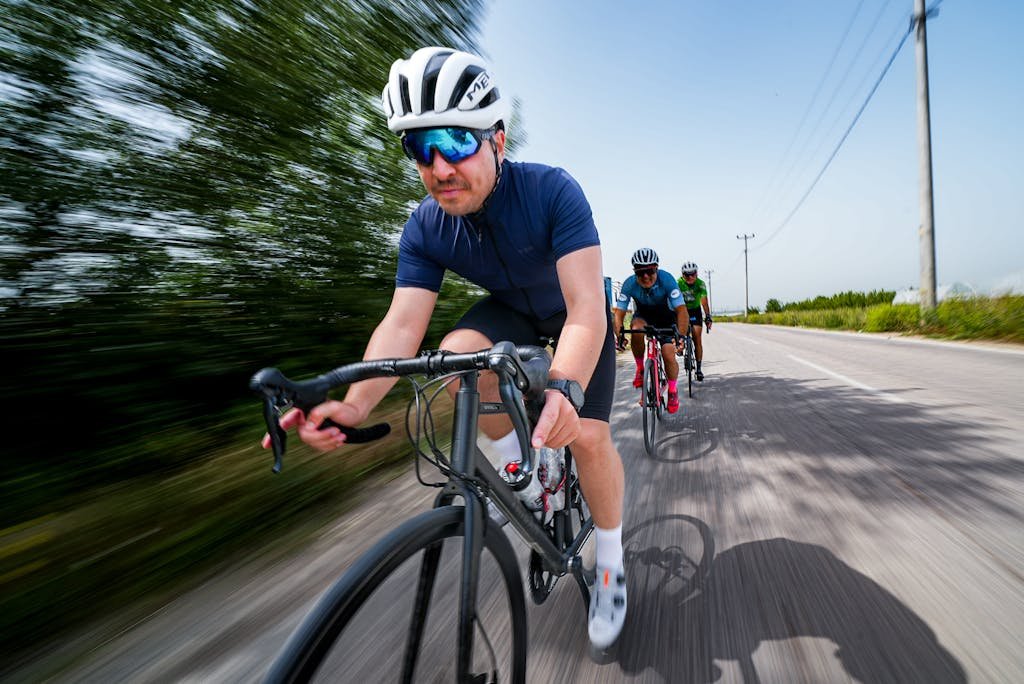 Dynamic shot of cyclists racing outdoors on a sunny road in Bursa, Türkiye.